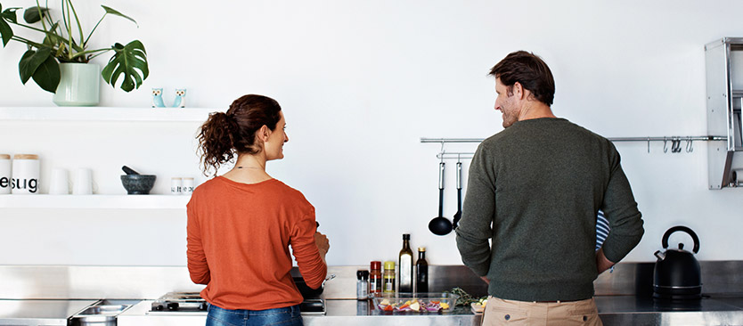 2 people in new kitchen looking at each other and smiling